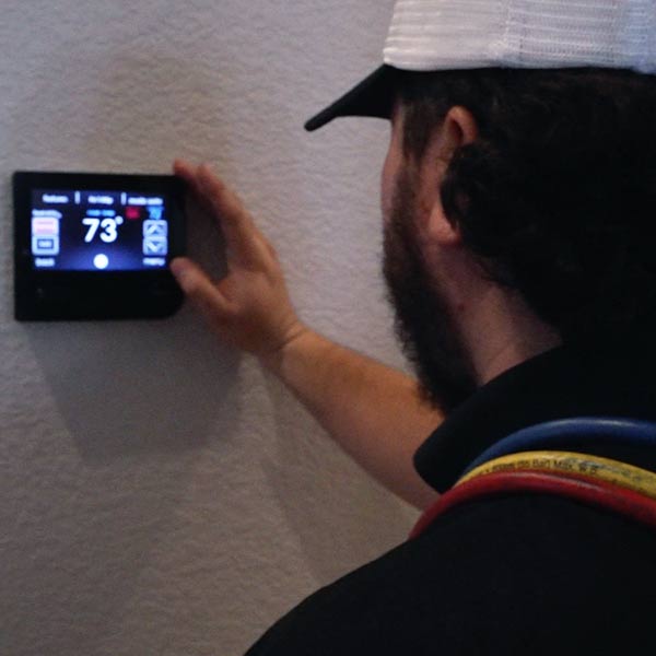 Local Air Technician works on Thermostat